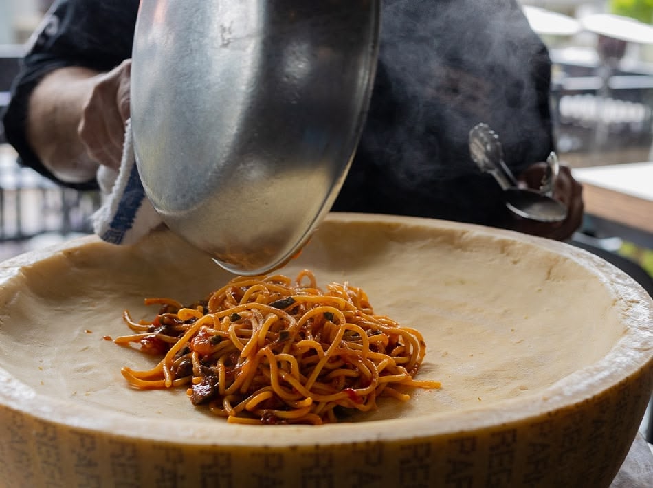 photo of pasta being prepared in a cheese wheel at Monello